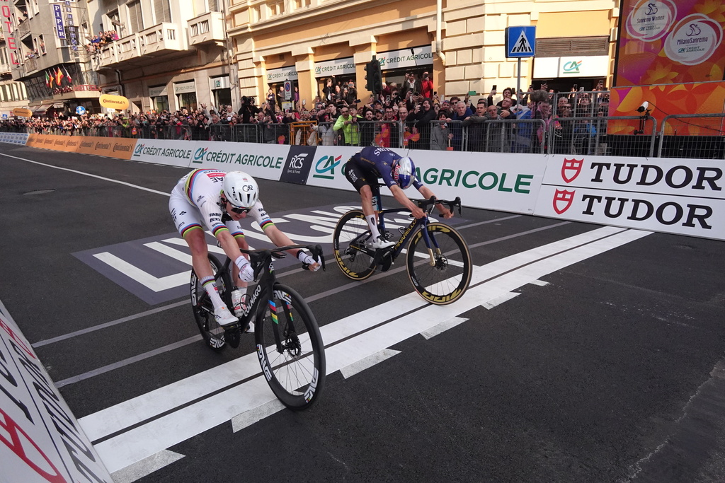 Slovenia's Tadej Pogacar of UAE Team Emirates XRG, left, crosses the finish line ahead of Britain's Thomas Pidcock of Pinarello-Q36.5 Pro Cycling Team, right, to win the men's elite race of the Milano-Sanremo one day cycling race (298 km) from Pavia to Sanremo, Italy, March 21, 2026. (Massimi Paolone/LaPresse via AP)