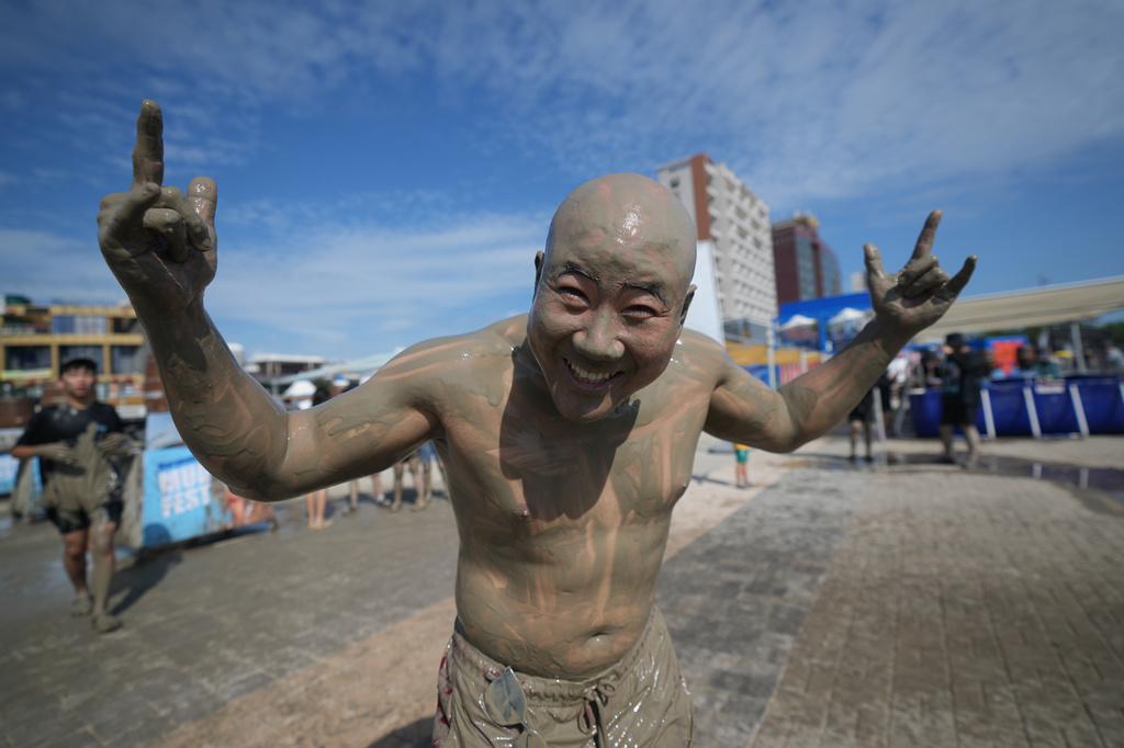 South Korean Ryan Kang, covered in mud, poses for a photo during the Boryeong Mud Festival near a beach in Boryeong, South Korea, Saturday, July 25, 2026. (AP Photo/Lee Jin-man)