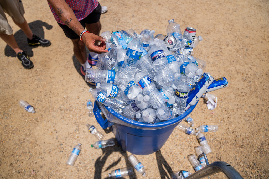 A trash can overflows with water at the Great American State Fair on the National Mall, Friday, July 3, 2026, in Washington. (AP Photo/Allison Robbert)