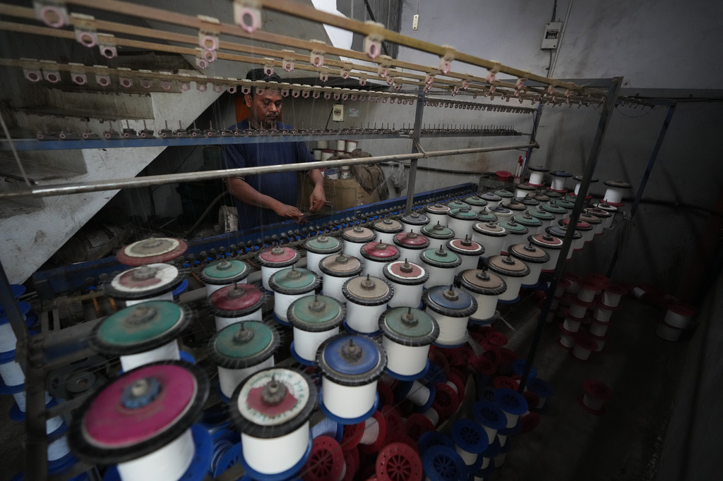 Sibaram Pradhan works at a power loom factory that produces polyester cloth at Anjani Industrial Estate in Surat, India, Wednesday, May 27, 2026. (AP Photo/Ajit Solanki)