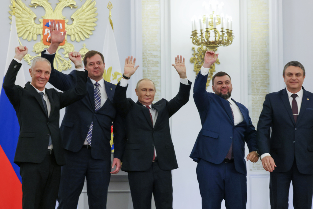 FILE - Russian President Vladimir Putin, center, with from left, Moscow-appointed head of Kherson Region Vladimir Saldo, Moscow-appointed head of Zaporizhzhia region Yevgeny Balitsky, Denis Pushilin, the leader of the Donetsk People's Republic and Leonid Pasechnik, leader of self-proclaimed Luhansk People's Republic wave during a ceremony to sign the treaties for four regions of Ukraine to join Russia, at the Kremlin, Moscow, Sept. 30, 2022. The signing of the treaties making the four regions part of Russia follows the completion of the Kremlin-orchestrated "referendums." (Mikhail Metzel, Sputnik, Kremlin Pool Photo via AP, File)