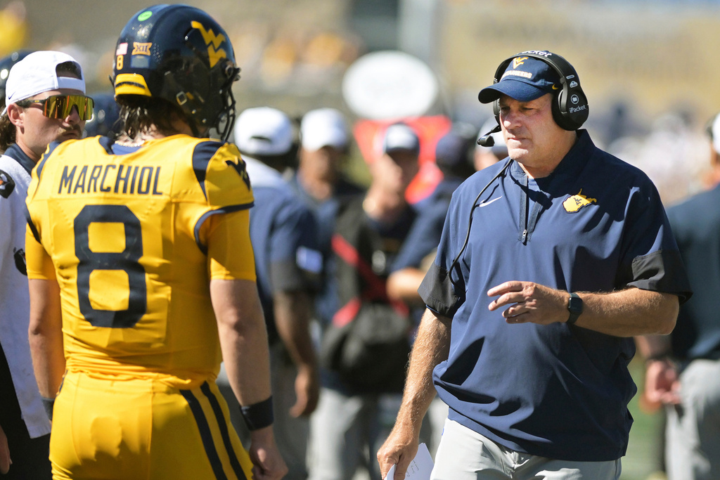 West Virginia coach Rich Rodriguez talks to quarterback Nicco Marchiol during the first half an NCAA college football game against Robert Morris, Saturday, Aug. 30, 2025, in Morgantown, W.Va. (Ron Rittenhouse/The Dominion-Post via AP)