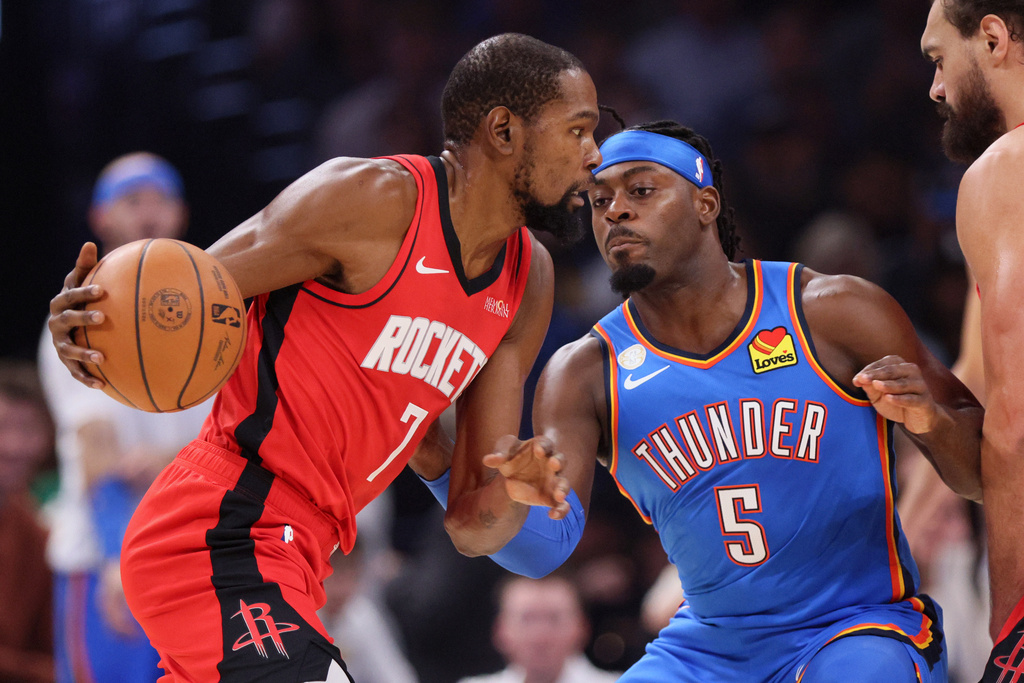 Houston Rockets forward Kevin Durant (7) drives against Oklahoma City Thunder guard Luguentz Dort (5) during the first half of an NBA basketball game Tuesday, Oct. 21, 2025, in Oklahoma City. (AP Photo/Nate Billings)