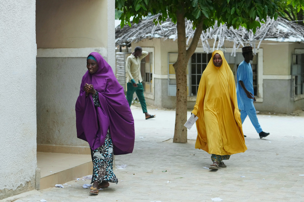 Ramatu Usman, a student who was dropped by the school, left and her mother Hajara Musa, walk past the school of Future Prowess Islamic Foundation, in Maiduguri, Nigeria, Thursday, July 24, 2025. (AP Photo/Sunday Alamba)
