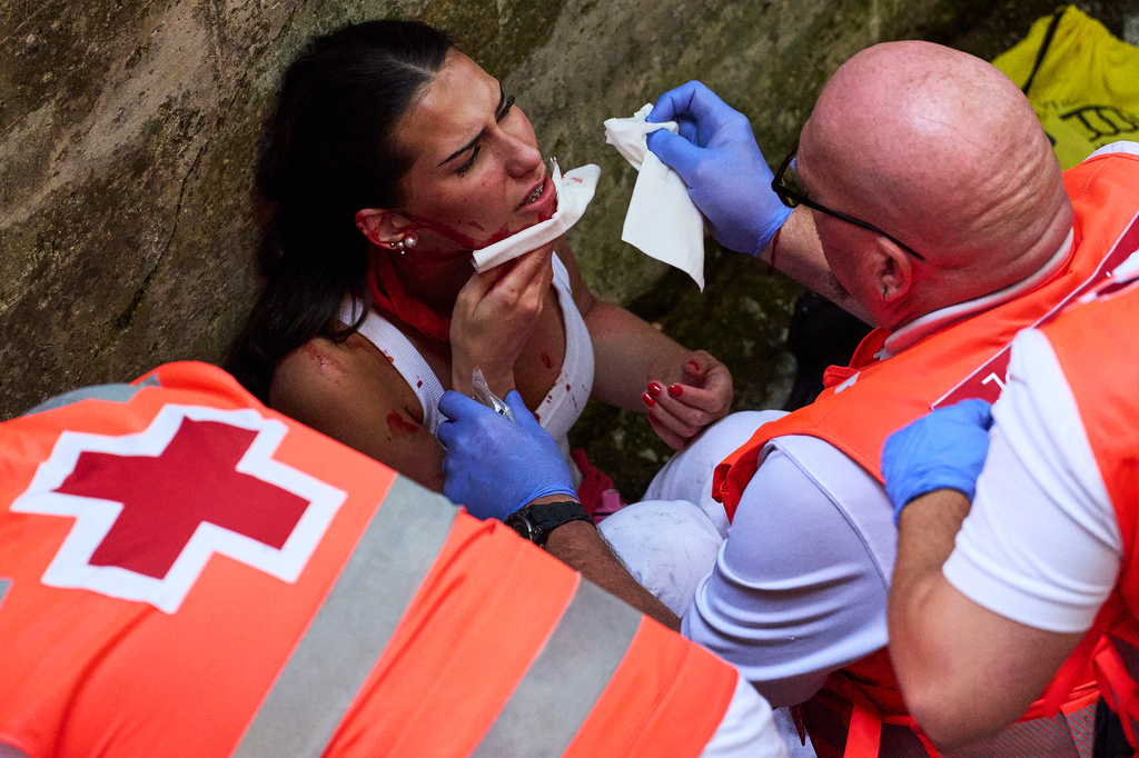 A medical team treats an injured reveler after the fifth running of the bulls at the San Fermín festival in Pamplona, Spain, Saturday, July 11, 2026. (AP Photo/Miguel Oses)