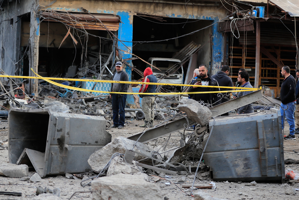 People check the site where an Israeli strike destroyed a building at a commercial district in the southern port city of Sidon, Lebanon, Tuesday, Jan. 6, 2026. (AP Photo/Mohammed Zaatari)