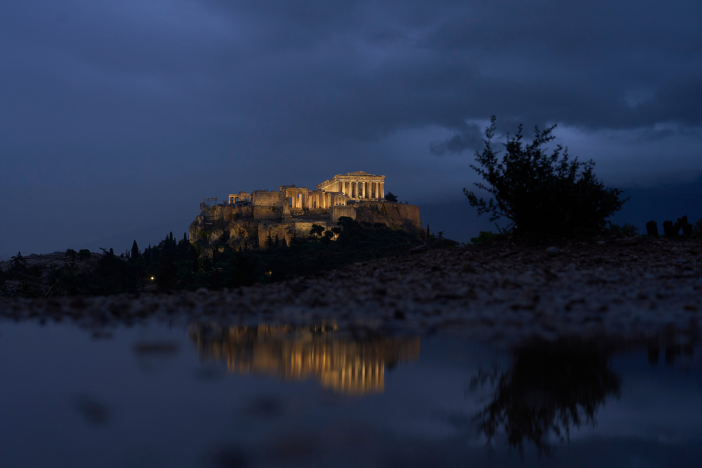 The Parthenon temple on the ancient Acropolis hill is reflected in a puddle after rainfall, Monday, Oct. 20, 2025. (AP Photo/Petros Giannakouris)