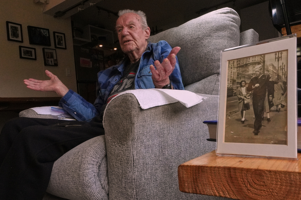 Freeman K. Johnson, a 106-year-old Pearl Harbor survivor, gestures during an interview, next to a photograph of himself on leave in 1943, at his home on May 6, 2026, in Centerville, Mass. (AP Photo/Charles Krupa)