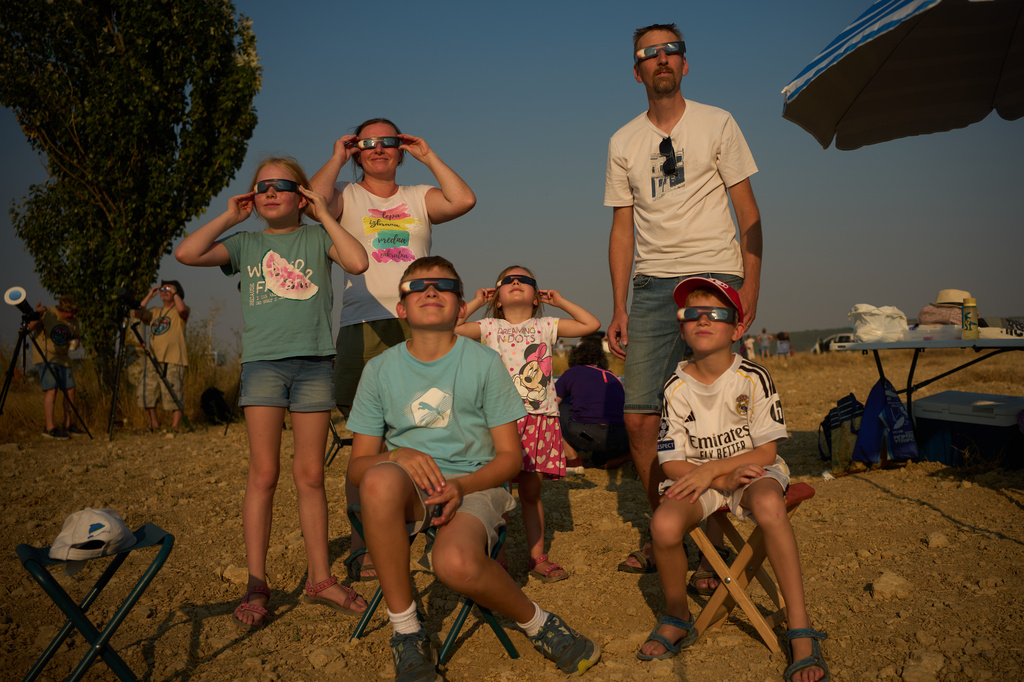 A family from Slovenia watches as the moon moves in front of the sun during a total solar eclipse in Palencia, Spain, Wednesday, Aug. 12, 2026. (AP Photo/Emilio Morenatti)