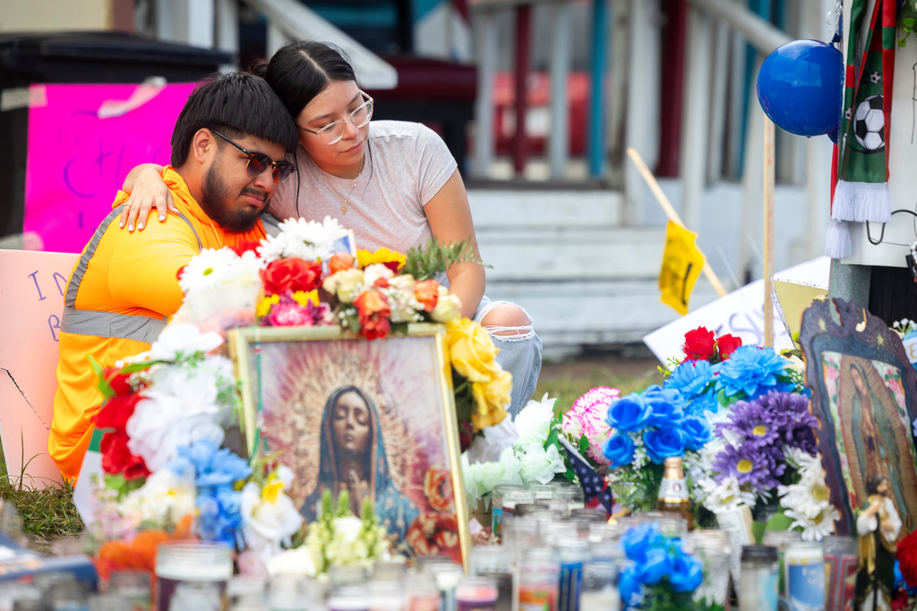 Albert Salgado, left, is comforted by his girlfriend at the site where his uncle Lorenzo Salgado Araujo was shot by an ICE officer in Houston on Friday, July 10, 2026. (AP Photo/Annie Mulligan)