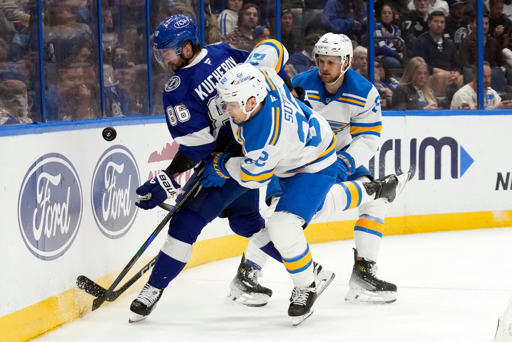 Tampa Bay Lightning right wing Nikita Kucherov (86) plays the puck against St. Louis Blues center Pius Suter (22) and defenseman Philip Broberg (6) during the second period of an NHL hockey game Monday, Dec. 22, 2025, in Tampa, Fla. (AP Photo/Chris O'Meara)