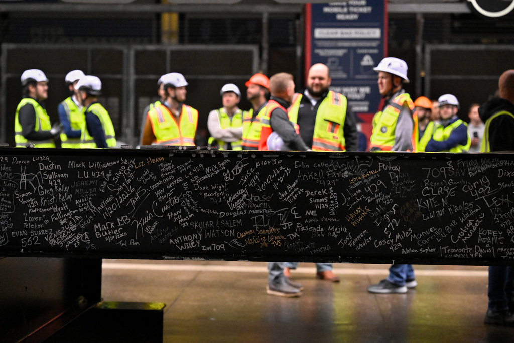 Construction workers gather in front of a steel beam they and other's signed during a topping out ceremony to celebrate the ongoing construction of the Tennessee Titans' new NFL football stadium, Friday, Nov. 21, 2025, in Nashville, Tenn. (AP Photo/John Amis)