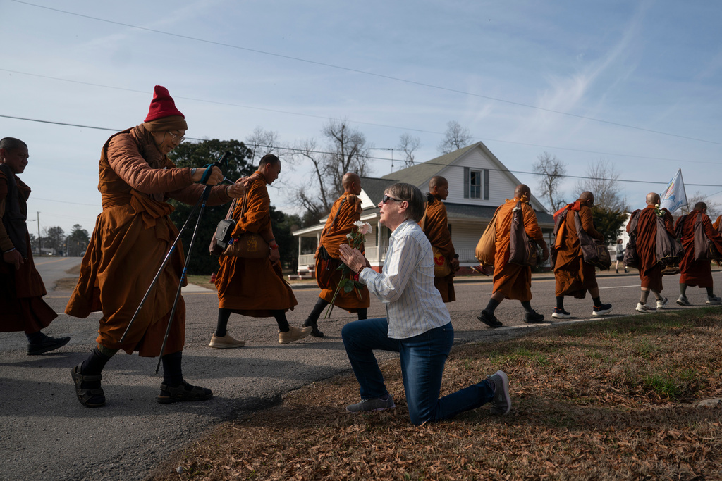 Audrie Pearce greets Buddhist monks who are participating in the "Walk For Peace," Thursday, Jan. 8, 2026, in Saluda, S.C. (AP Photo/Allison Joyce)