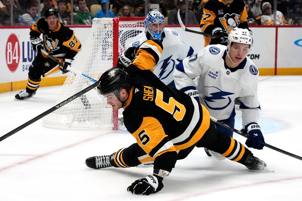 Pittsburgh Penguins' Ryan Shea (5) collides with Tampa Bay Lightning's Yanni Gourde (37) in front of Andrei Vasilevskiy (88) during the second period of an NHL hockey game in Pittsburgh, Tuesday, Jan. 13, 2026. (AP Photo/Gene J. Puskar)