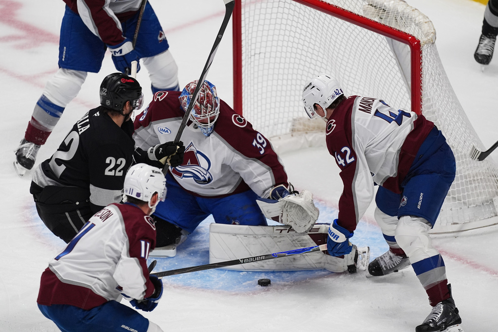 Los Angeles Kings left wing Kevin Fiala, back left, has his shot stopped by Colorado Avalanche goaltender Mackenzie Blackwood, center, as center Brock Nelson, front left, and defenseman Josh Manson cover in the first period of an NHL hockey game, Monday, Dec. 29, 2025, in Denver. (AP Photo/David Zalubowski)