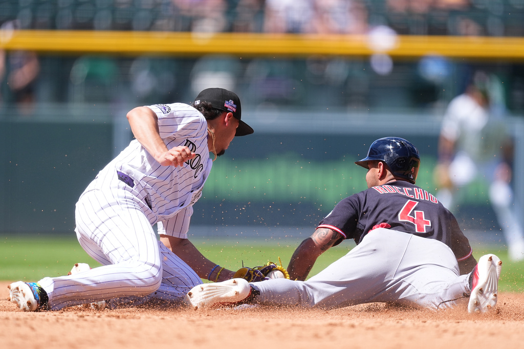 Cleveland Guardians' Brayan Rocchio, right, steals second base as Colorado Rockies shortstop Ezequiel Tovar, left, applies a late tag in the second inning of a baseball game Sunday, Aug. 23, 2026, in Denver. (AP Photo/David Zalubowski)