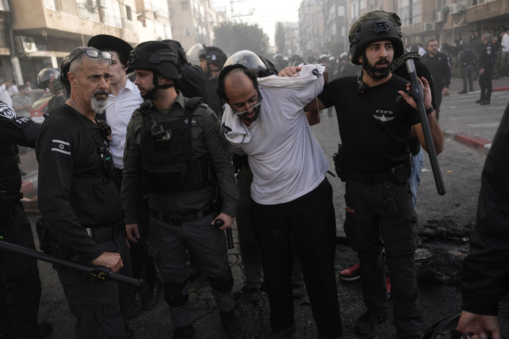 Israeli police detain an ultra-Orthodox Jewish man after two female Israeli soldiers were rescued from riots that broke out during a welfare visit in the ultra-Orthodox city of Bnei Brak, near Tel Aviv, Israel, Sunday, Feb. 15, 2026. (AP Photo/Oded Balilty)