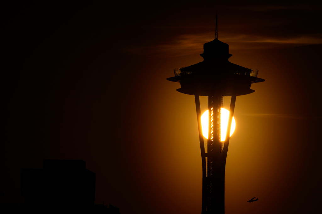 FILE - The sun sets behind the Space Needle as a small plane flies by on the first day of spring, Tuesday, March 19, 2024, in Seattle. (AP Photo/Lindsey Wasson,File)