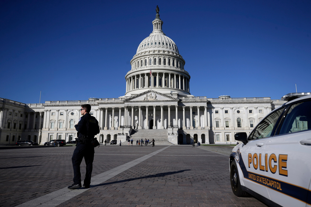 A U.S. Capitol Police officer patrols on the East Front of the U.S. Capitol, Friday, Oct. 17, 2025, in Washington. (AP Photo/Rahmat Gul)