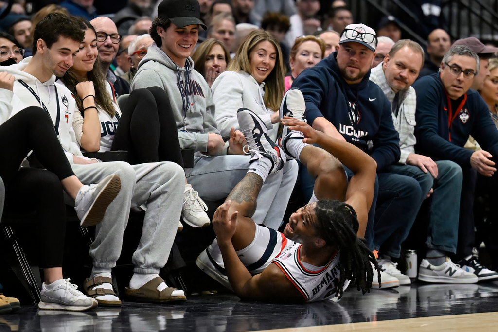 UConn guard Silas Demary Jr. slides into fans while chasing the ball in the first half of an NCAA college basketball game against DePaul Blue, Saturday, Jan. 10, 2026, in Hartford, Conn. (AP Photo/Jessica Hill)
