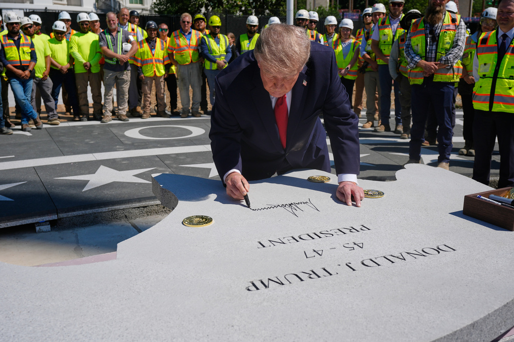 President Donald Trump signs a stone outside the White House, Wednesday, Aug. 19, 2026, in Washington, at the construction site of the new helicopter landing zone on the South Lawn of the White House. (AP Photo/Manuel Balce Ceneta)
