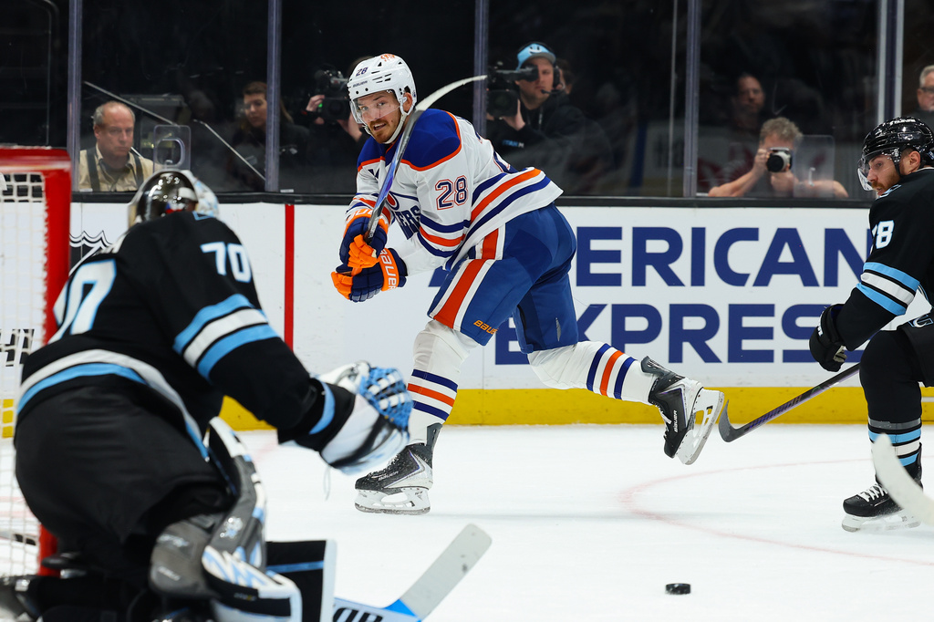 Edmonton Oilers right wing Quinn Hutson (28) shoots the puck against the Utah Mammoth during the second period of an NHL hockey game, Tuesday, April 7, 2026, in Salt Lake City. (AP Photo/Melissa Majchrzak)