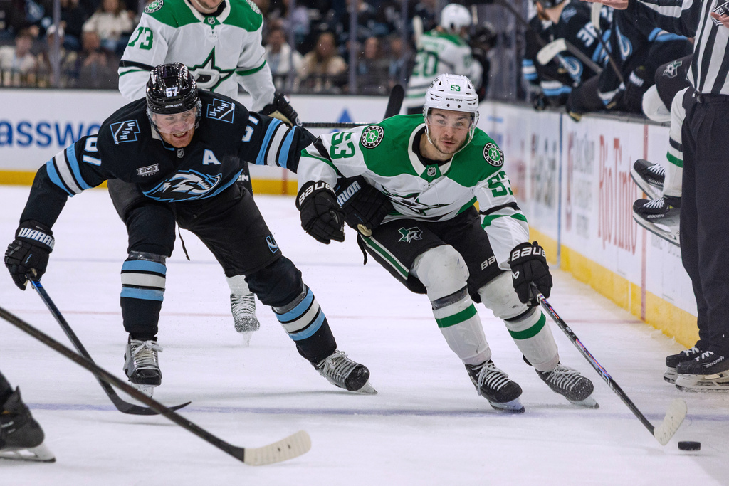 Dallas Stars center Wyatt Johnston, right, moves the puck against Utah Mammoth left wing Lawson Crouse during the second period of an NHL hockey game Thursday, Jan. 15, 2026, in Salt Lake City. (AP Photo/Melissa Majchrzak)