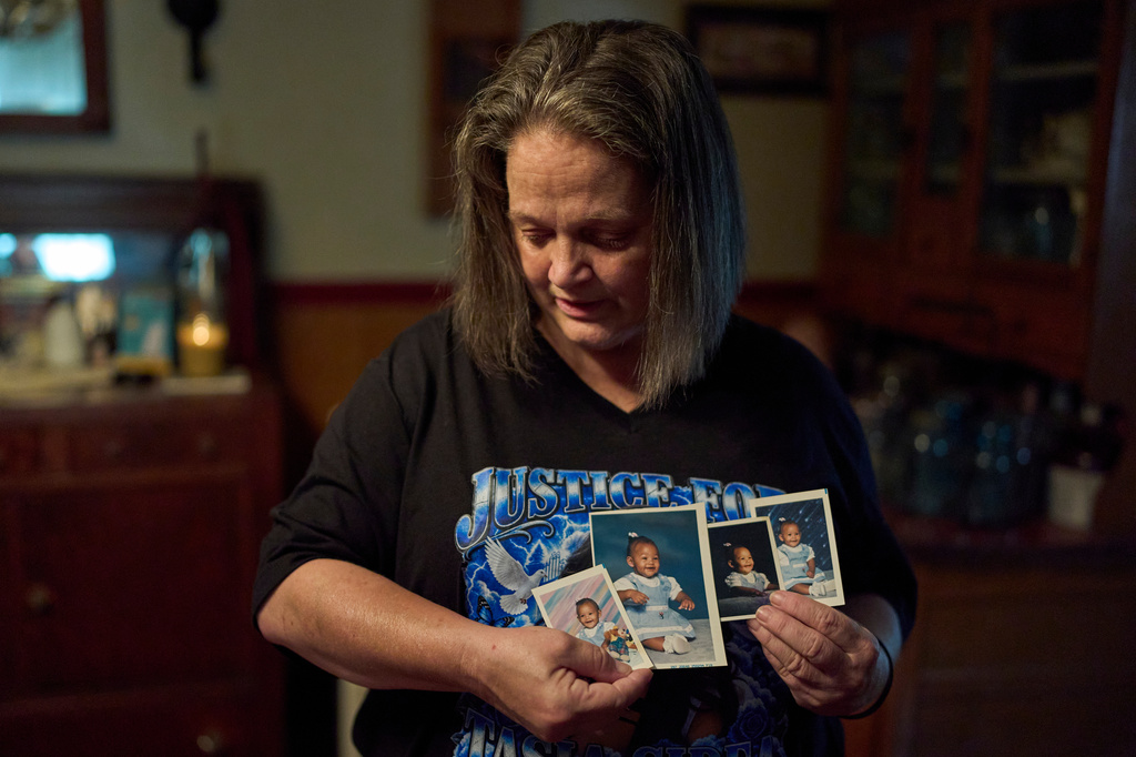Christy Spivey hold baby pictures of her late daughter, Tasia Fortune, on Tuesday, Sept. 8, 2026, in Marion, Ky. (AP Photo/George Walker IV)