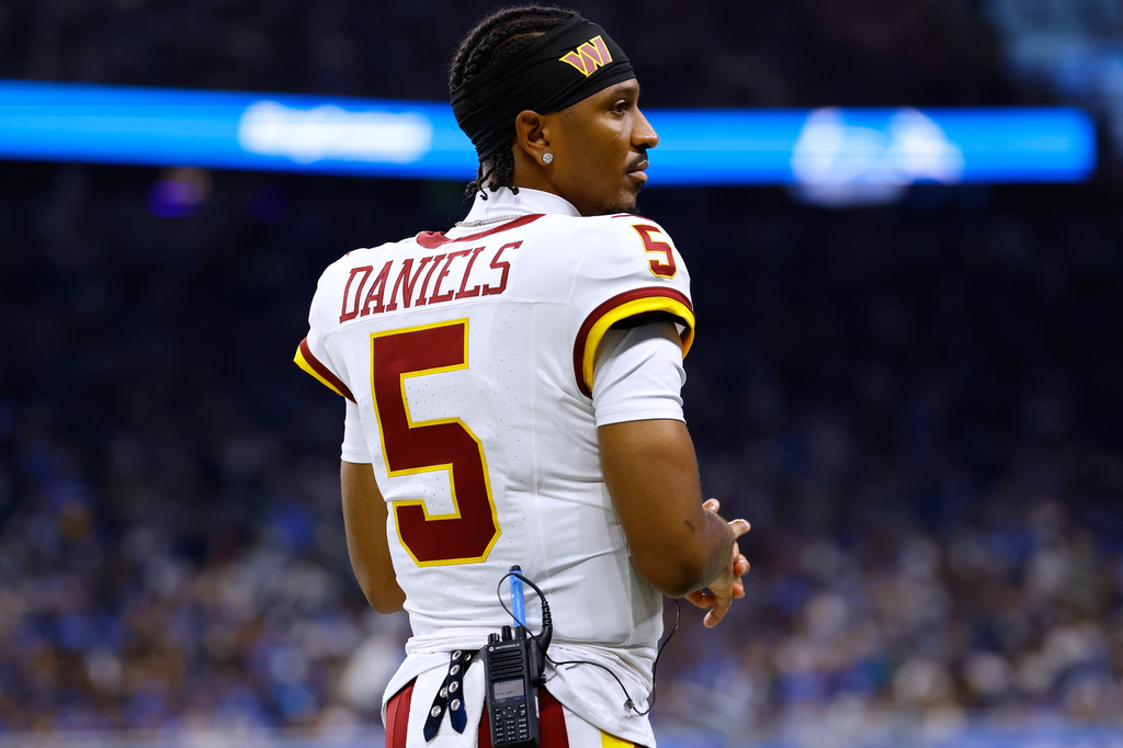 Washington Commanders quarterback Jayden Daniels (5) watches from the sidelines during a preseason NFL football game against the Detroit Lions, Saturday, Aug. 22, 2026, in Detroit. (AP Photo/Rey Del Rio)