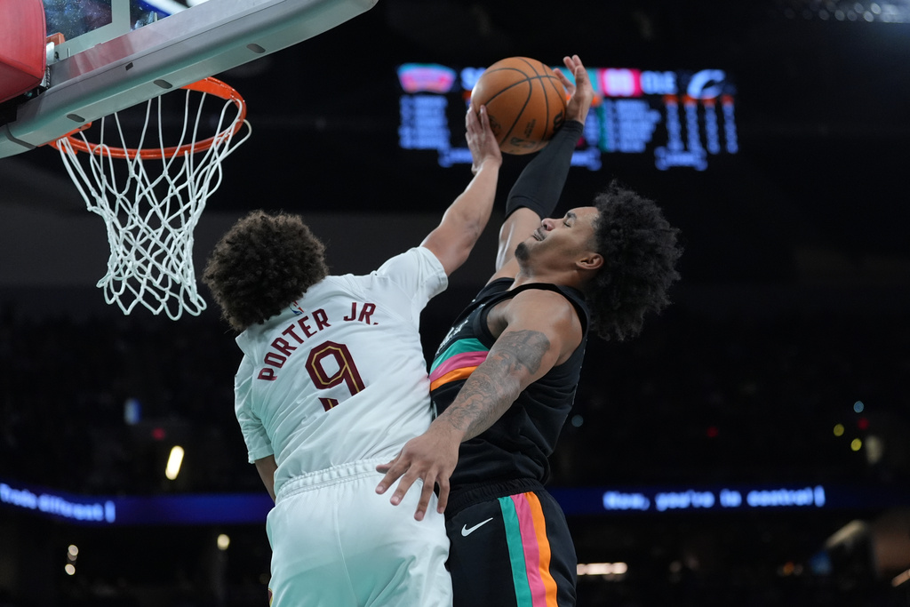 San Antonio Spurs guard Dylan Harper, right, is blocked by Cleveland Cavaliers guard Craig Porter Jr. (9) as he drives to the basket during the second half of an NBA basketball game in San Antonio, Monday, Dec. 29, 2025. (AP Photo/Eric Gay)