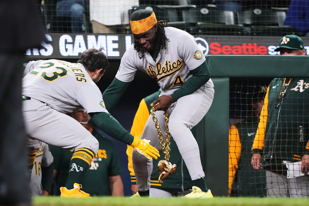 Athletics' Shea Langeliers (23) is greeted by Lawrence Butler (4), holding a gold elephant chain, as they celebrate Langeliers' solo home run against the Seattle Mariners during the seventh inning of a baseball game, Tuesday, April 21, 2026, in Seattle. (AP Photo/Lindsey Wasson)