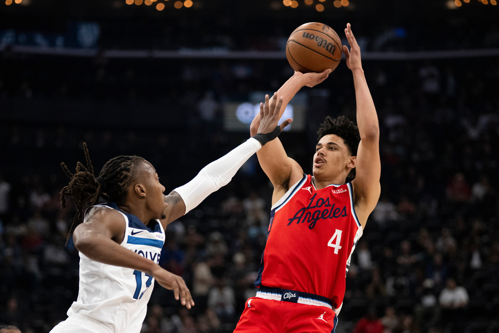 Los Angeles Clippers guard Kobe Sanders, right, shoots as Minnesota Timberwolves guard Ayo Dosunmu defends during the first half of an NBA basketball game Thursday, Feb. 26, 2026, in Inglewood, Calif. (AP Photo/Kyusung Gong)