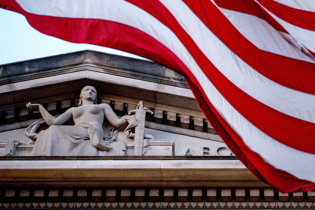 FILE - An American flag flies outside the Department of Justice in Washington, March 22, 2019. (AP Photo/Andrew Harnik, File)