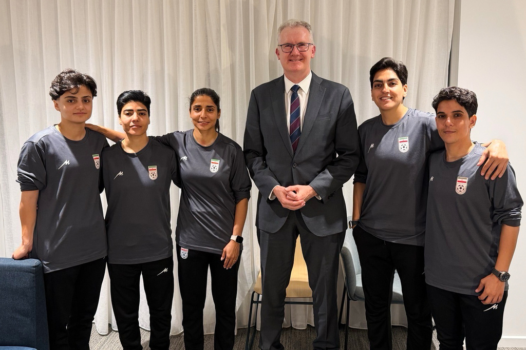 In this photo supplied by Australia's Minister for Home Affairs Tony Burke's office, the Minister Tony Burke, center, poses in an undisclosed location with five Iranian women soccer players who have been granted asylum in Australia, Tuesday, March 10, 2026. (Australia Ministry of Home Affairs via AP)