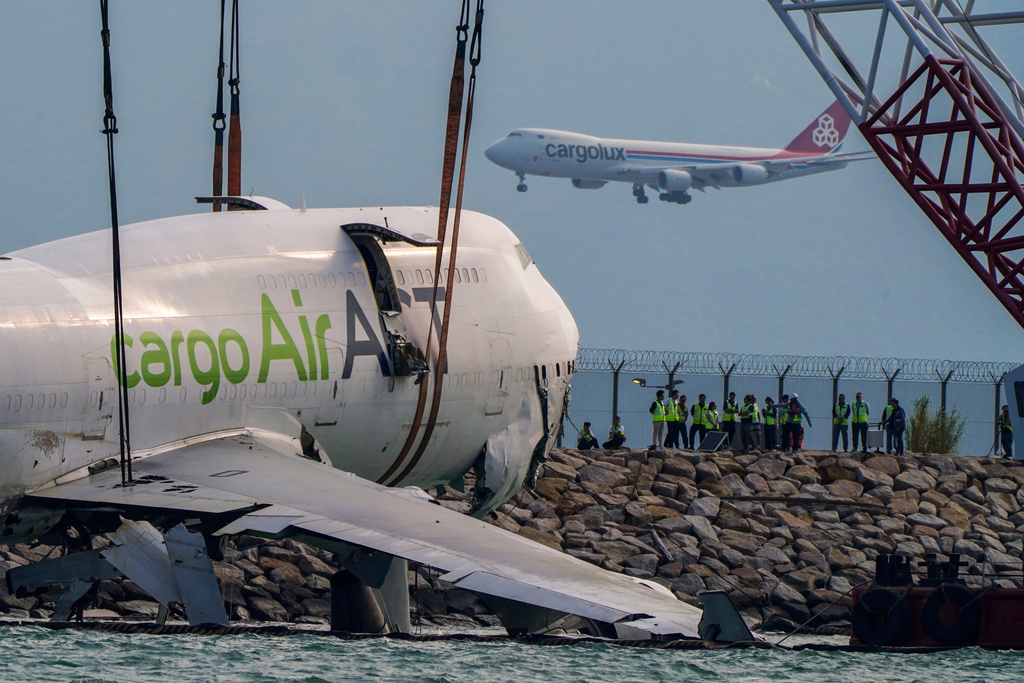The wreckage of a cargo aircraft that skidded off a runway at the Hong Kong International Airport is prepared for removal on Sunday, Oct. 26, 2025. (AP Photo/Vernon Yuen)