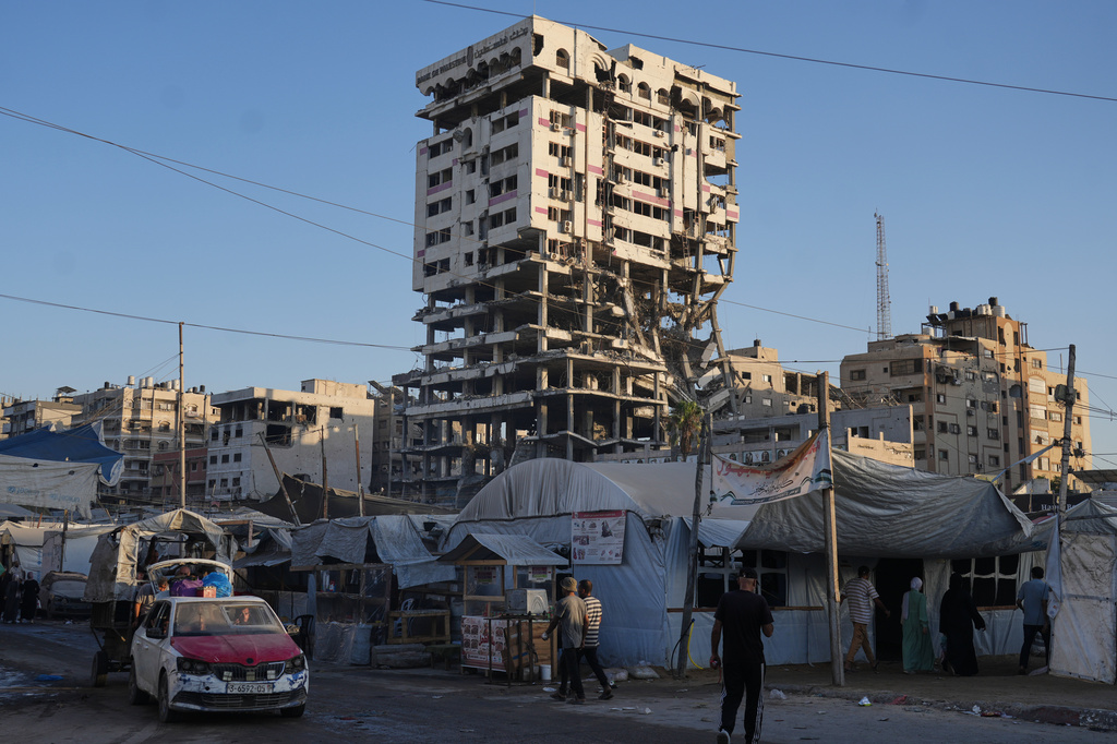 Tents sheltering displaced Palestinians and a market surround a building heavily damaged during the Israel-Hamas war in Gaza City, Thursday, Sept. 17, 2026. (AP Photo/Jehad Alshrafi)