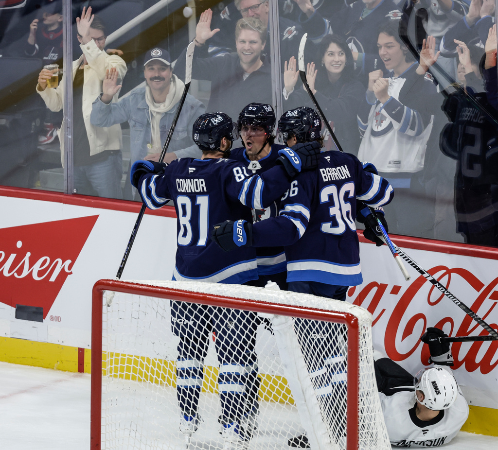 Winnipeg Jets' Morgan Barron (36), Kyle Connor (81) and Mark Scheifele (55) celebrate Scheifele's goal against Los Angeles Kings goaltender Darcy Kuemper (35) during the second period of an NHL game in Winnipeg, Manitoba, Saturday, Oct. 11, 2025. (John Woods/The Canadian Press via AP)