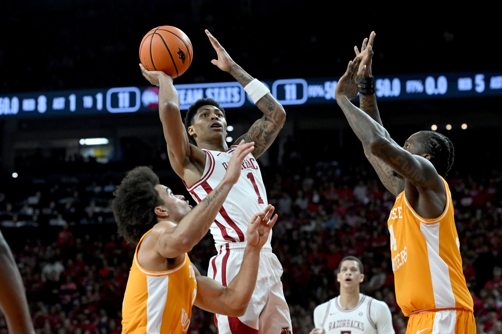 Arkansas guard Meleek Thomas (1) shoots over Tennessee defenders Ja'Kobi Gillespie, left, and Felix Okpara, right, during the first half of an NCAA college basketball game Saturday, Jan. 3, 2026, in Fayetteville, Ark. (AP Photo/Michael Woods)