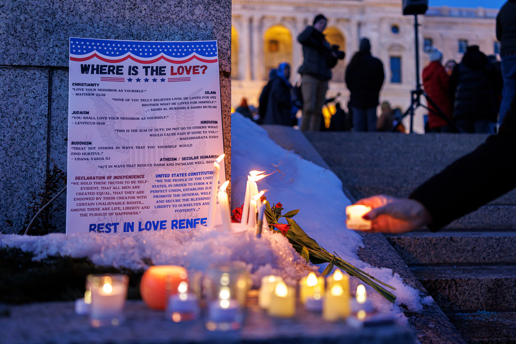 Candles burn around a poem written by Renee Nicole Good during a vigil honoring Good, outside the State Capitol, in St. Paul, Minn., Friday, Jan. 9, 2026, (Kerem Yücel/Minnesota Public Radio via AP)