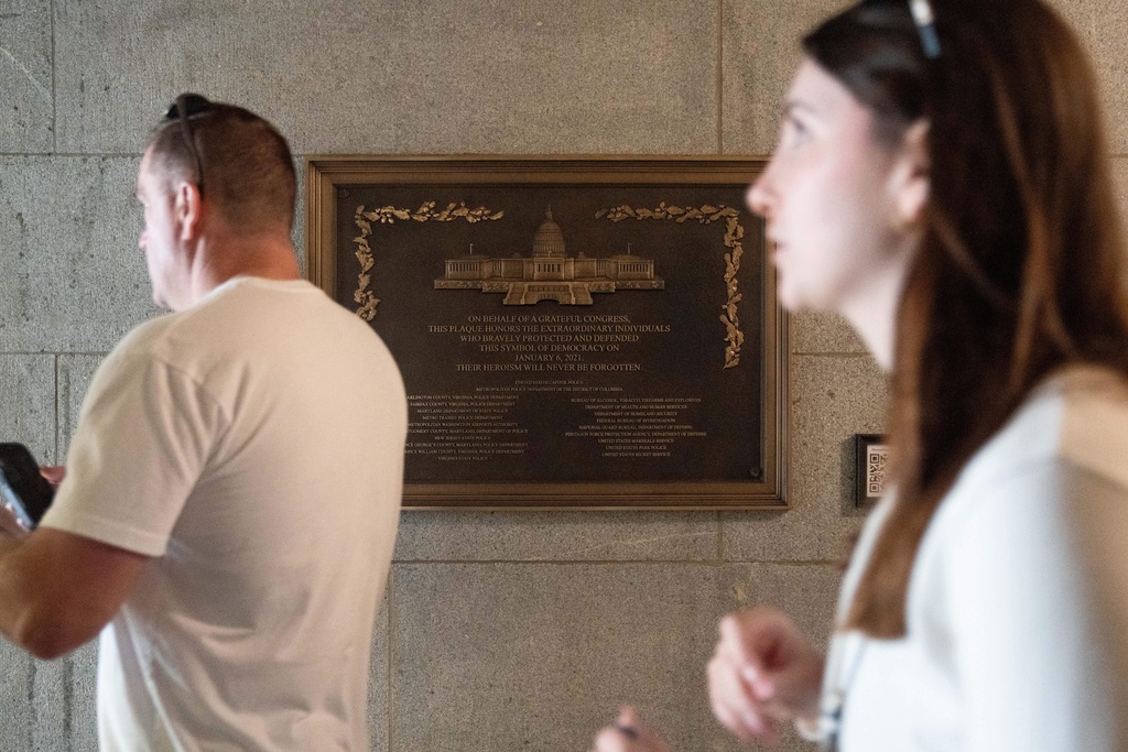 A tour group walks by a plaque honoring police service on Jan. 6, 2021 at the Capitol, Saturday, March 7, 2026, in Washington. (AP Photo/Allison Robbert)
