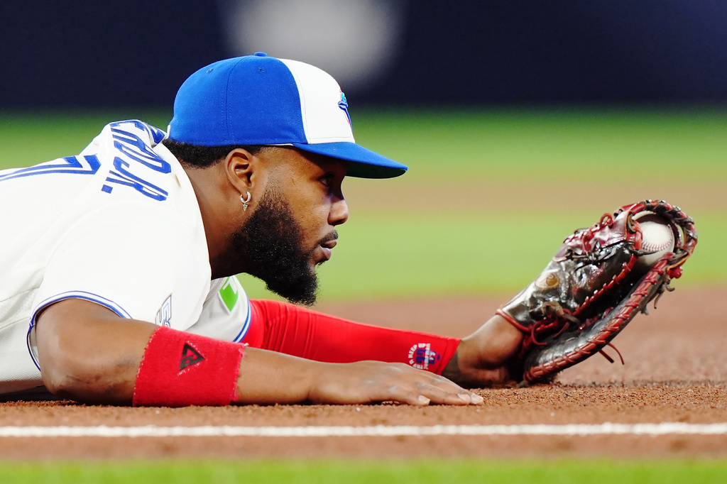 Toronto Blue Jays first baseman Vladimir Guerrero Jr. (27) holds on to the ball after forcing out Athletics' Tyler Soderstrom during the fourth inning of a baseball game in Toronto on Friday, March 27, 2026. (Nathan Denette/The Canadian Press via AP)