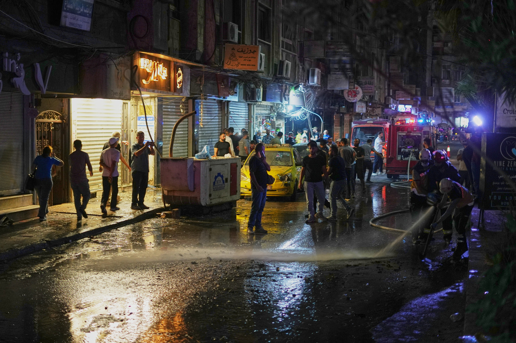 Residents watch as Syrian firefighters clean the site of an explosion in the Jaramana suburb, home to a large Druze population, in Damascus, Syria, Thursday, Aug. 6, 2026. (AP Photo/Omar Albam)