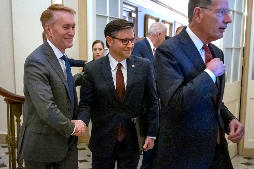 Speaker of the House Mike Johnson, of La., center, shakes hands with Sen. James Lankford, R-Okla., left, as they walk with Senate Majority Whip John Barrasso, of Wyo., right to a press conference at the Capitol on Wednesday, Oct. 1, 2025, in Washington. (AP Photo/Mark Schiefelbein)