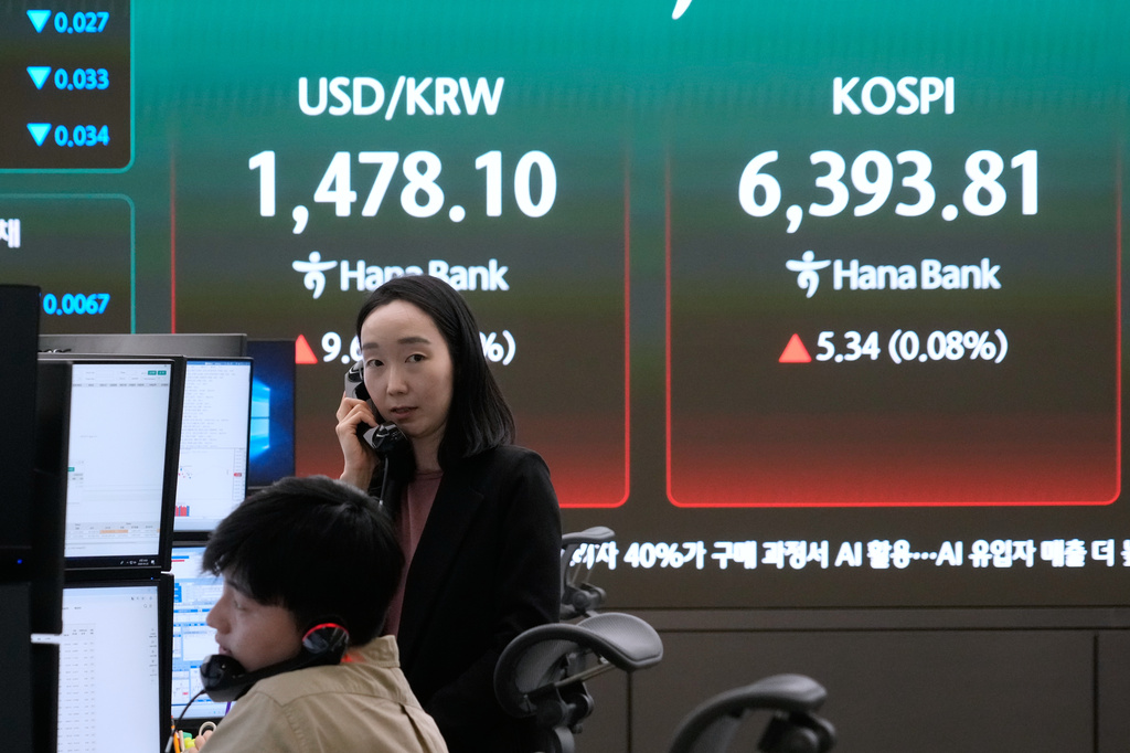 Currency traders talk on the phones near a screen showing the Korea Composite Stock Price Index (KOSPI), right, and the foreign exchange rate between U.S. dollar and South Korean won at the foreign exchange dealing room of the Hana Bank headquarters in Seoul, South Korea, Wednesday, April 22, 2026. (AP Photo/Ahn Young-joon)