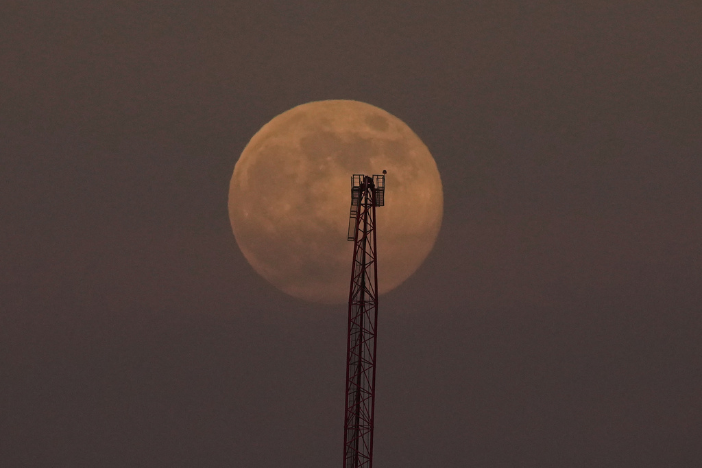 A supermoon, the last full moon of the year, rises in the sky behind a crane in San Francisco, Thursday, Dec. 4, 2025. (AP Photo/Jeff Chiu)