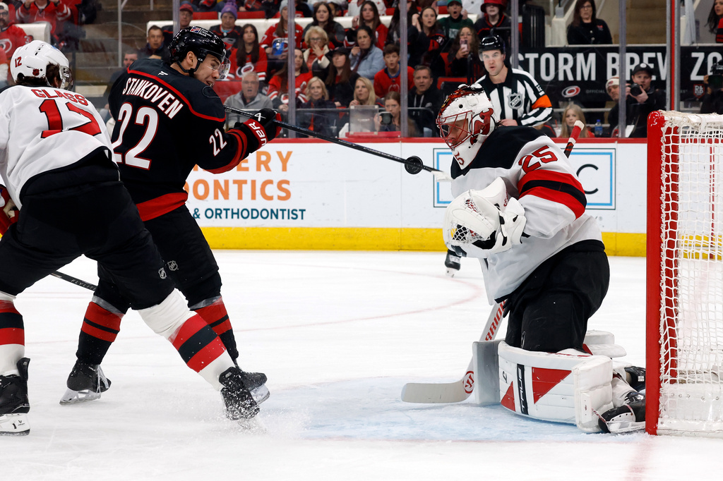 Carolina Hurricanes' Logan Stankoven (22) tries to play the puck in front of New Jersey Devils goaltender Jacob Markstrom (25) during the second period of an NHL hockey game in Raleigh, N.C., Saturday, March 28, 2026. (AP Photo/Karl DeBlaker)