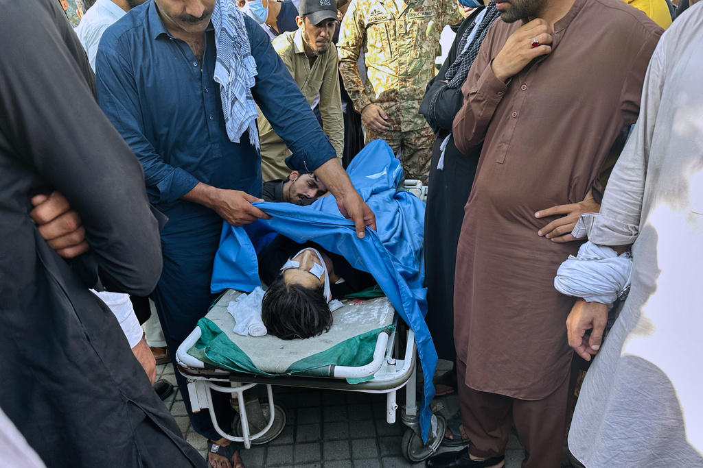 People gather around the body of a person, who was killed in the clashes between police and demonstrators demanding subsidies on food, cheaper electricity and other concession, at a hospital in Muzaffarabad, the capital of Pakistani controlled Kashmir, Wednesday, Oct. 1, 2025. (AP Photo/M.D. Mughal)