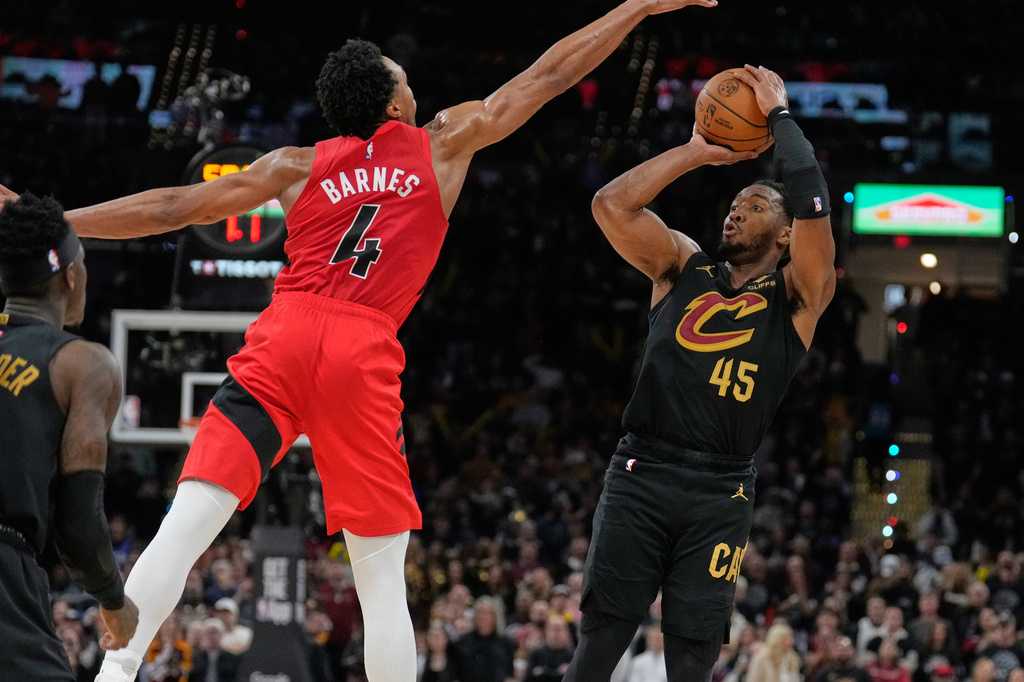 Cleveland Cavaliers guard Donovan Mitchell (45) shoots as Toronto Raptors forward Scottie Barnes (4) defends in the second half in Game 7 of a first-round NBA basketball playoffs series in Cleveland, Sunday, May 3, 2026. (AP Photo/Sue Ogrocki)