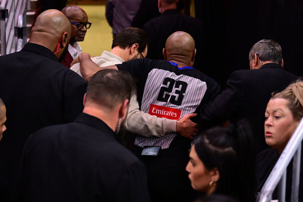 Referee Tre Maddox, center, is assisted by members of the training staff after sustaining an injury running off the floor in the first half of an NBA basketball game between the Cleveland Cavaliers and Chicago Bulls, Friday, Dec. 19, 2025, in Cleveland. (AP Photo/David Dermer)