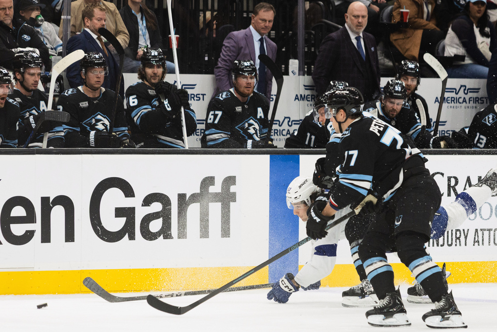 Tampa Bay Lightning center Dominic James (17) fights for the puck against Utah Mammoth right wing JJ Peterka (77) and defenseman Nate Schmidt, center, during the first period of an NHL hockey game Sunday, Nov. 2, 2025, in Salt Lake City. (AP Photo/Melissa Majchrzak)